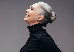 Smiling older woman with grey hair wearing her hair in a bun